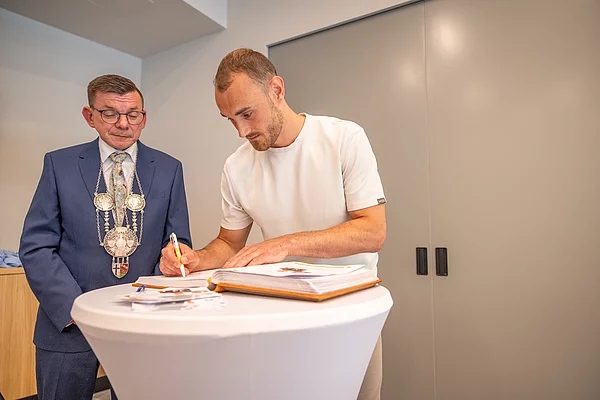 Moritz Karlitzek trägt sich als erster Sportbotschafter der Stadt Hammelburg in das Goldene Buch ein.
